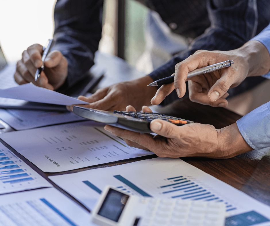 Expert comptable Paris 15 analysant des documents financiers avec un collègue et utilisant une calculatrice